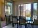 Bright dining area with a modern glass-top table and sleek black chairs, sliding glass doors to patio at 7147 S Durango Dr # 211, Las Vegas, NV 89113