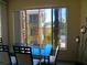 Dining area with a glass-top table, four chairs, and a large window offering neighborhood views at 7147 S Durango Dr # 211, Las Vegas, NV 89113