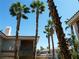 Palm trees frame views of a multi-story residential building and its balcony and neutral exterior at 7147 S Durango Dr # 211, Las Vegas, NV 89113