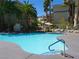 Community pool surrounded by lush landscaping and palm trees, offering a resort-like experience at 7147 S Durango Dr # 211, Las Vegas, NV 89113
