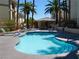 Inviting community pool area surrounded by lush palm trees and lounge chairs at 7147 S Durango Dr # 211, Las Vegas, NV 89113