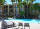 Inviting pool with lounge chairs and palm trees, creating a relaxing oasis for residents to enjoy at 7147 S Durango Dr # 211, Las Vegas, NV 89113