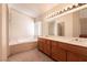 Bright bathroom with large vanity, soaking tub, and a separate window at 7620 Tortola Bay Ln, Las Vegas, NV 89128