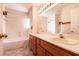 Well-lit bathroom with double vanity, large mirror, and bathtub with shower at 7620 Tortola Bay Ln, Las Vegas, NV 89128