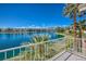 Breathtaking lake view from balcony with palm trees and mountain backdrop on a sunny day at 7620 Tortola Bay Ln, Las Vegas, NV 89128