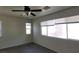 Bedroom with modern ceiling fan, neutral walls and flooring, offering generous natural light through multiple windows at 8768 Charm Canyon Ave, Las Vegas, NV 89178