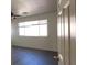 Bright bedroom with neutral walls, modern ceiling fan and dark flooring, illuminated by a large window at 8768 Charm Canyon Ave, Las Vegas, NV 89178