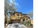 Two-story home featuring a two-car garage, stone accents and desert landscaping at 8768 Charm Canyon Ave, Las Vegas, NV 89178