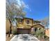 Two-story home featuring a two-car garage, stone accents and desert landscaping at 8768 Charm Canyon Ave, Las Vegas, NV 89178