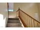 A carpeted stairway with wooden banister and railing leads upstairs, illuminated by a window on the upper level at 8768 Charm Canyon Ave, Las Vegas, NV 89178