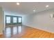 Spacious living room featuring wood floors, three large windows, and neutral paint at 9050 W Tropicana Ave # 1053, Las Vegas, NV 89147