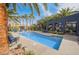 Community pool surrounded by lounge chairs and lush palm trees in a serene setting at 9050 W Tropicana Ave # 1053, Las Vegas, NV 89147