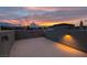 Open rooftop patio with lights offering a stunning view of the colorful sunset over distant mountains at 9050 W Tropicana Ave # 1053, Las Vegas, NV 89147