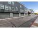 Street view of modern townhomes featuring gray exteriors, garages, and manicured landscaping at 9050 W Tropicana Ave # 1053, Las Vegas, NV 89147