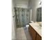 Cozy bathroom with shower and curtain and a white single sink vanity at 9641 Windborne Ave, Las Vegas, NV 89147
