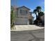 Two-story home showcasing a large garage, desert landscaping, and a red-tile roof under a clear blue sky at 9641 Windborne Ave, Las Vegas, NV 89147
