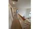 Hallway with carpeted floor and wooden railing overlooking the living room at 9641 Windborne Ave, Las Vegas, NV 89147