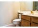Bathroom featuring a wooden vanity, white sink, and a toilet at 9704 Falling Star Ave, Las Vegas, NV 89117