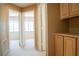 Hallway featuring tan walls, carpeted floors, and wooden cabinets at 9704 Falling Star Ave, Las Vegas, NV 89117