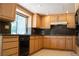 Well-lit kitchen featuring wooden cabinets, stone countertops and tile flooring at 9704 Falling Star Ave, Las Vegas, NV 89117