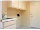 Laundry room featuring storage cabinets, a sink and a white door at 9704 Falling Star Ave, Las Vegas, NV 89117