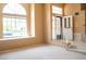 Inviting living room featuring large windows, a decorative door, and neutral carpet at 9704 Falling Star Ave, Las Vegas, NV 89117