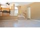 Open concept living room with tile flooring, staircase, and an adjacent kitchen at 9704 Falling Star Ave, Las Vegas, NV 89117