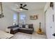 Comfortable bedroom with a gray sectional, window views, and a ceiling fan at 9772 Alpine Style Dr, Las Vegas, NV 89166