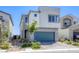 Modern two-story home with gray stucco, a blue-green garage door, and low maintenance front yard at 9772 Alpine Style Dr, Las Vegas, NV 89166