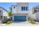 Modern two-story home with gray stucco, blue-green garage door, and landscaped front yard at 9772 Alpine Style Dr, Las Vegas, NV 89166