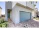 Modern home featuring a large blue-green garage door and a landscaped entrance at 9772 Alpine Style Dr, Las Vegas, NV 89166