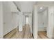 Hallway featuring wood-look floors, white walls, and mirrored closet doors at 9962 Catalina Canyon Ave, Las Vegas, NV 89147