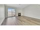 Bright living room featuring a modern fireplace, wood floors, and a sliding glass door to the backyard at 9962 Catalina Canyon Ave, Las Vegas, NV 89147