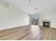 Spacious living room featuring wood flooring, modern fireplace and light, with a sliding glass door to the back yard at 9962 Catalina Canyon Ave, Las Vegas, NV 89147
