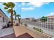 View of the side yard with palm trees, rock cover, white fence, and exterior of the home at 9962 Catalina Canyon Ave, Las Vegas, NV 89147
