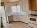 Compact kitchen features tile flooring, corner sink and painted cabinets at 1020 Wengert Ave, Las Vegas, NV 89104