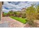 Beautiful backyard featuring a brick patio, artificial turf, and desert landscaping at 10425 White Princess Ave, Las Vegas, NV 89166