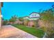 Backyard with artificial turf, brick patio, and desert landscaping under a blue sky at 10425 White Princess Ave, Las Vegas, NV 89166