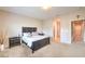 Spacious bedroom featuring a plush bed, neutral carpet, and a view into the hallway at 10425 White Princess Ave, Las Vegas, NV 89166