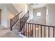 Beautiful staircase with carpeted steps and wood railing illuminated by a hanging light fixture at 10425 White Princess Ave, Las Vegas, NV 89166