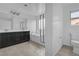 Bright bathroom with double vanity, a bathtub with shower, tile floors, and a toilet at 10728 Brewster Bay St, Las Vegas, NV 89179