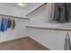 Spacious walk-in closet with ample hanging space and neutral brown carpet, perfect for organization at 10728 Brewster Bay St, Las Vegas, NV 89179