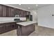 Kitchen featuring dark cabinets, white granite countertops, and center island at 10728 Brewster Bay St, Las Vegas, NV 89179