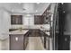 Well-lit kitchen with dark wood cabinetry, granite countertops, and stainless steel appliances at 10728 Brewster Bay St, Las Vegas, NV 89179