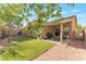 Landscaped backyard features manicured synthetic grass, gravel area, and a covered patio at 10741 Pearl River Ave, Las Vegas, NV 89166