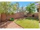 Backyard featuring artificial turf, mature landscaping, and brick perimeter wall at 10741 Pearl River Ave, Las Vegas, NV 89166