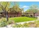 Landscaped front yard with mature trees, lawn, walkway, and exterior view of home at 10741 Pearl River Ave, Las Vegas, NV 89166