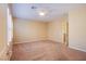 Bedroom featuring tan carpet, a ceiling fan, and a door to the en suite at 11242 Almador Vista Ct, Las Vegas, NV 89135