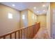 Well-lit upstairs hallway featuring wood railing and tan carpet at 11242 Almador Vista Ct, Las Vegas, NV 89135