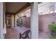 Outdoor patio with brick pavers, privacy wall, mature landscaping and a chair at 11242 Almador Vista Ct, Las Vegas, NV 89135